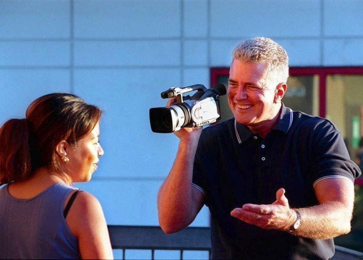 Huell Howser with his camera interviews Marleni Salgado.