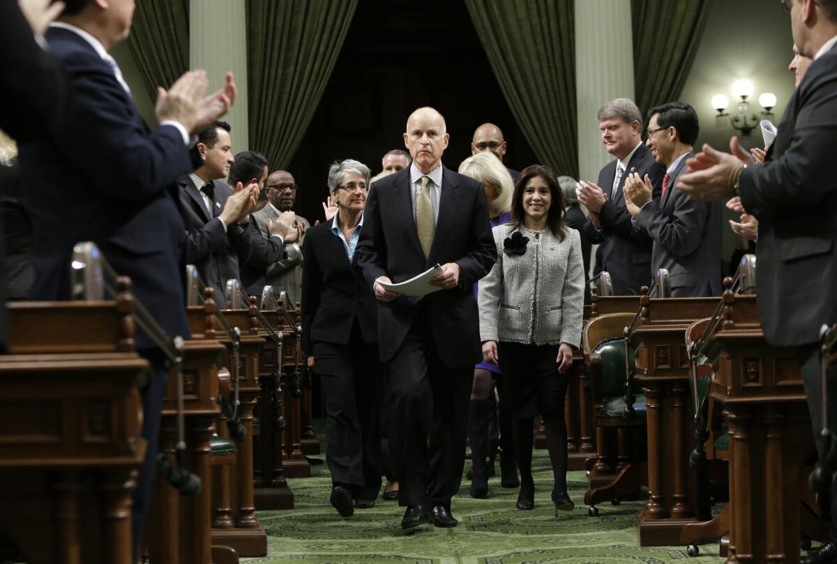 Gov. Jerry Brown enters the Assembly Chambers at the Capitol in Sacramento, Calif.