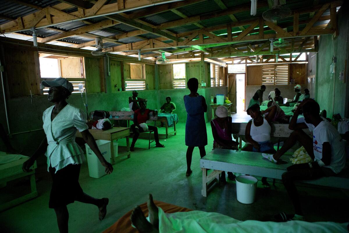 Patients accompanied by family members rest inside a cholera ward in Les Cayes, Haiti