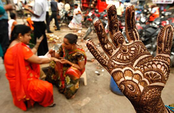 Indian women are given intricate henna tattoos as they observe Karwa Chauth. During the festival, married Hindu women fast throughout the day and then dine in the evening after looking at the moon through a sieve to seek long life for their husbands.