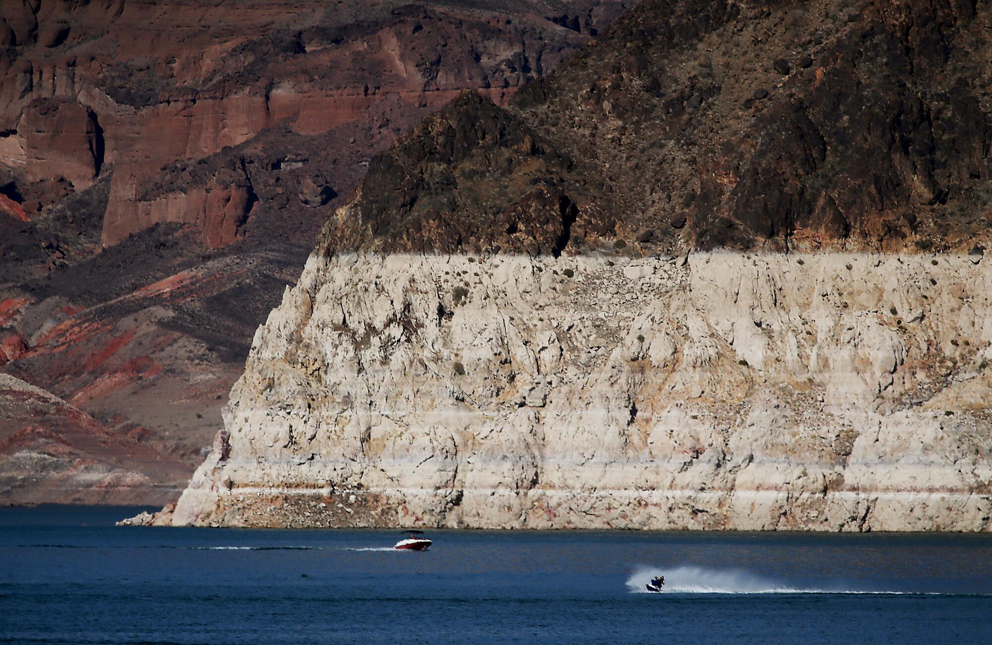 Boaters are dwarfed by a white "bathtub ring" around Lake Mead. 