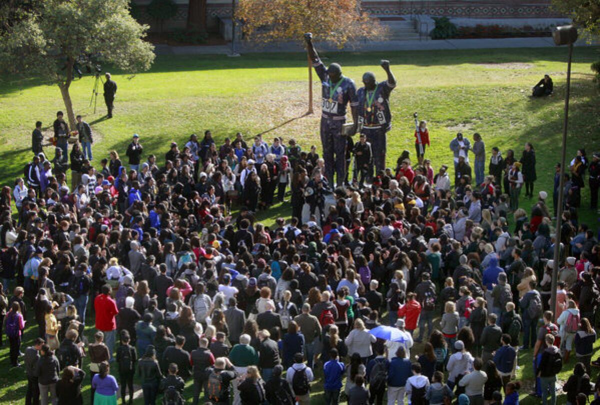 San Jose State students gather Thursday around the 1968 Olympic statue of Tommie Smith and John Carlos while protesting an alleged hate crime against a black student in the dorms.