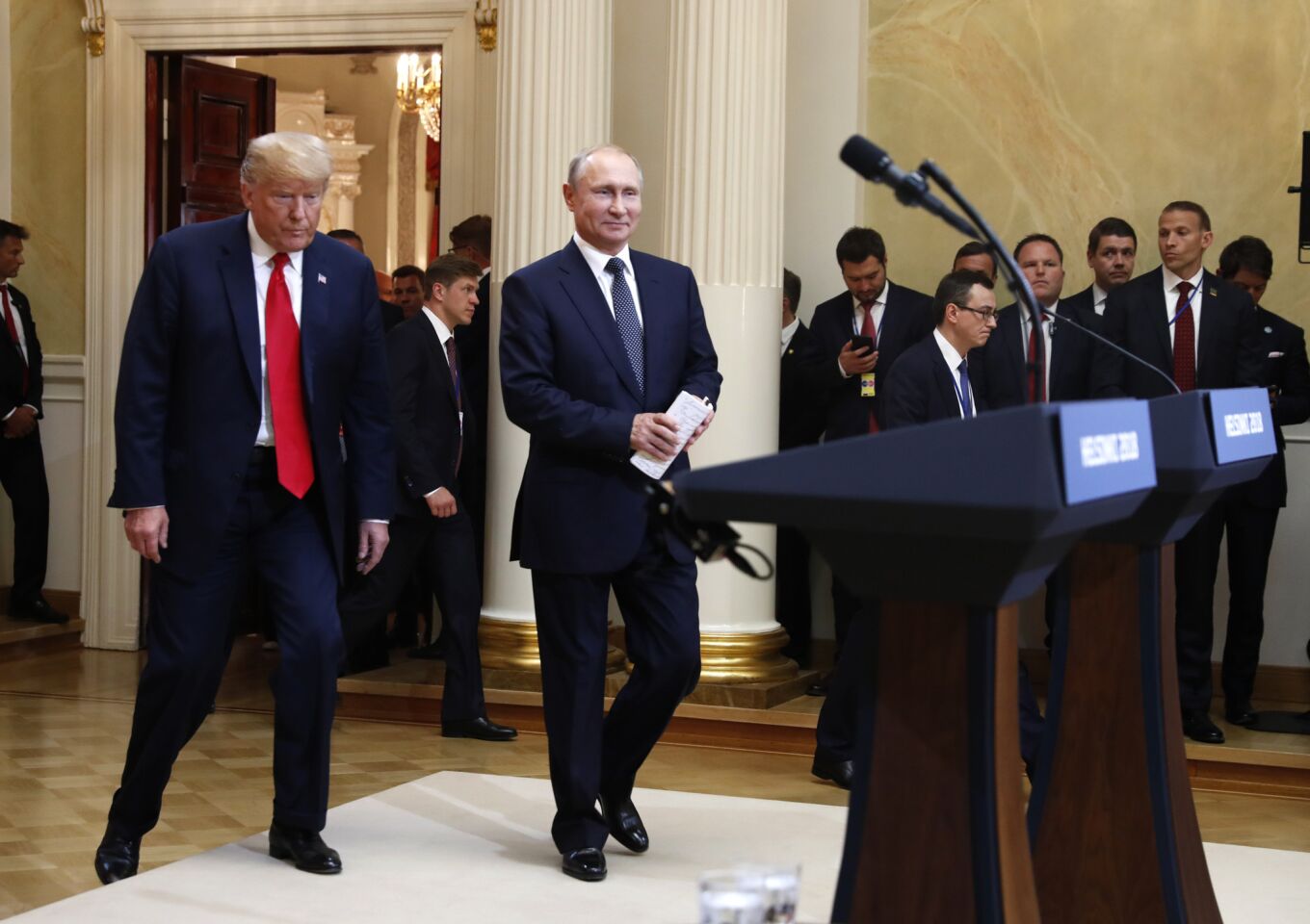 President Trump, left, and Russian President Vladimir Putin arrive for a press conference after their meeting at the Presidential Palace in Helsinki, Finland.