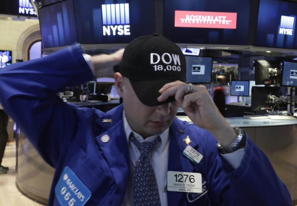 Specialist Mario Picone adjusts his Dow 18,000 as he works on the floor of the New York Stock Exchange, Friday. Dow missed reaching the record after Labor Department report showed U.S. employers added 321,000 jobs last month, the biggest burst of hiring in nearly three years.