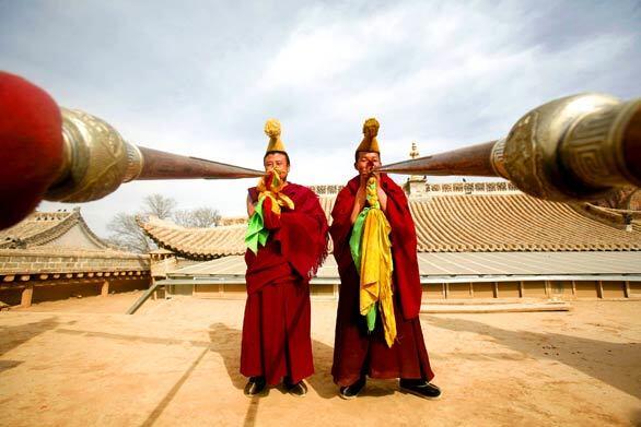 Lamas perform a ritual during the annual Buddha Thangka unfolding ceremony at the Wutun Shang Tibetan Buddhist monastery in Qinghai province, China. Thangka is a kind of Tibetan tapestry woven with gold or silk, usually with an embroidered image of Buddha on the surface.