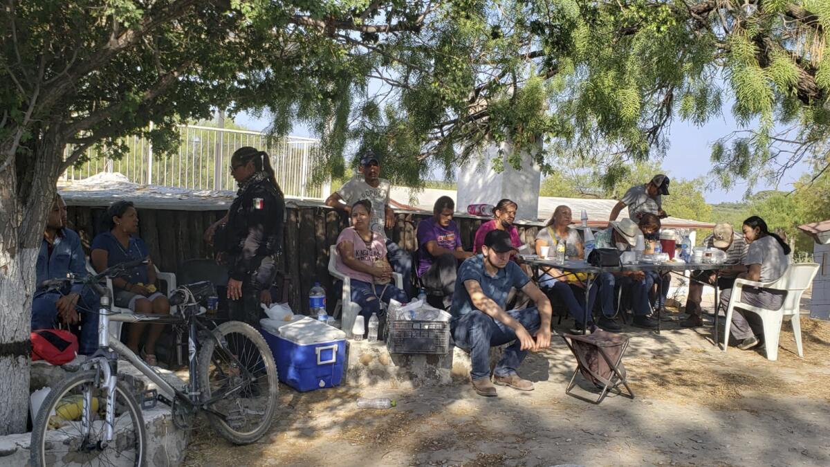 Familiares de mineros atrapados en una mina de carbón colapsada e inundada esperan información afuera de la mina