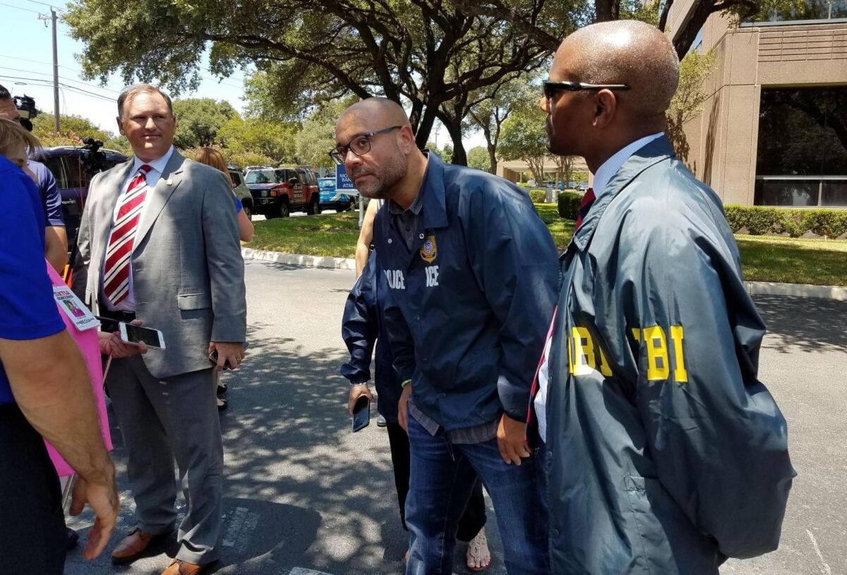 Agentes del FBI inspeccionan el lugar donde alguien disparó a dos edificios de San Antonio, Texas, donde trabajan empleados del Servicio de Control de Inmigración y Aduanas.