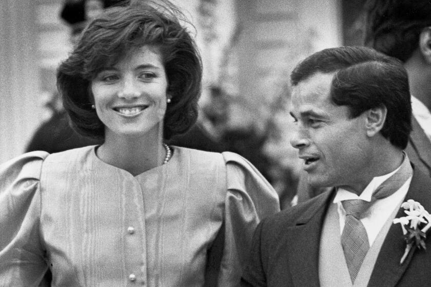 Caroline Kennedy and best man Franco Columbu leave St. Francis Xavier Church after the wedding of Caroline's cousin Maria Shriver to Arnold Schwarzenegger in Hyannis, Mass. in 1986.