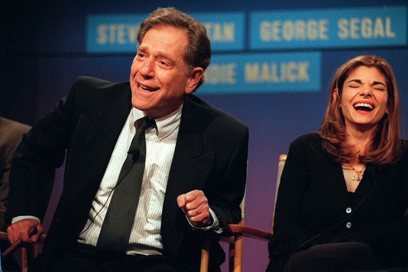 FILE - Cast members from the NBC "Just Shoot Me," George Segal, left, and Laura San-Giacomo appear at the TCA winter press tour in Pasadena, Calif. on Jan. 10, 1997. Segal, the banjo player turned actor who was nominated for an Oscar for 1966's “Who’s Afraid of Virginia Woolf?,” and starred in the ABC sitcom “The Goldbergs,” and the NBC sitcom "Just Shoot Me," died Tuesday, his wife said. He was 87. (AP Photo/Kevork Djansezian, File)