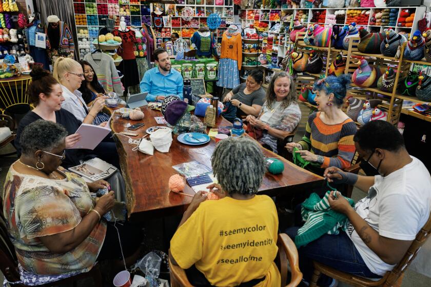 INGLEWOOD, CA - JULY 31, 2024: Knitters gather around a community table to work on their latest knitting projects at The Knitting Tree LA on July 31, 2024 in Inglewood, California. Every Sunday and Wednesday, a dedicated group of knitters of all colors, ages and life experience gather around a big table to work on their knitting projects. They talk about everything under the sun including politics.(Gina Ferazzi / Los Angeles Times)