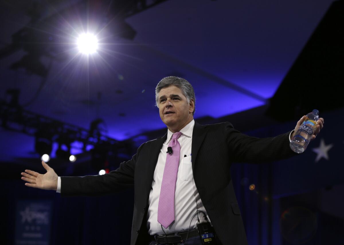 Sean Hannity of Fox News spreads his arms wide as he appears at a Maryland event in 2016.