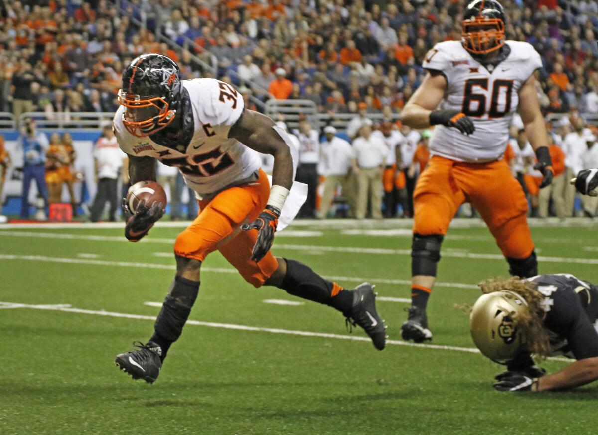 Oklahoma State's Chris Carson (32) eludes the tackle of Buffaloes linebacker Addison Gillam (44) for his team's first touchdown in the Valero Alamo Bowl on Dec. 29.