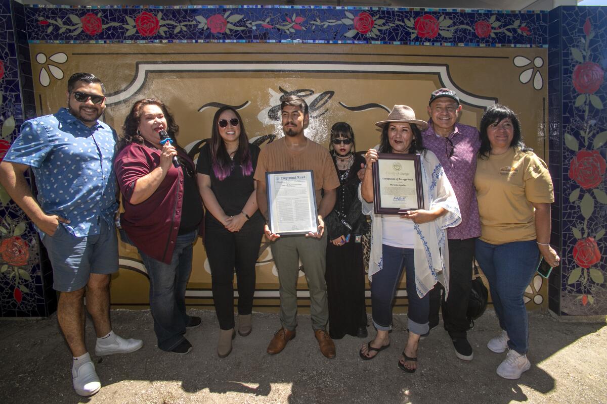 Artist Marina Aguilera, right, holds a Certificate of Recognition with Councilman Hernandez and his daughter, Evoni.