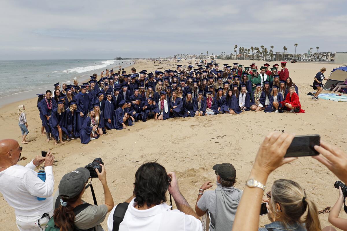 Parents take a group picture of Newport-Mesa Unified School District seniors before they participate in a graduation walk.