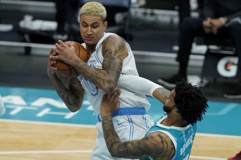 Los Angeles Lakers forward Kyle Kuzma pulls a rebound away from Charlotte Hornets forward Miles Bridges during the first half in an NBA basketball game on Tuesday, April 13, 2021, in Charlotte, N.C. (AP Photo/Chris Carlson)