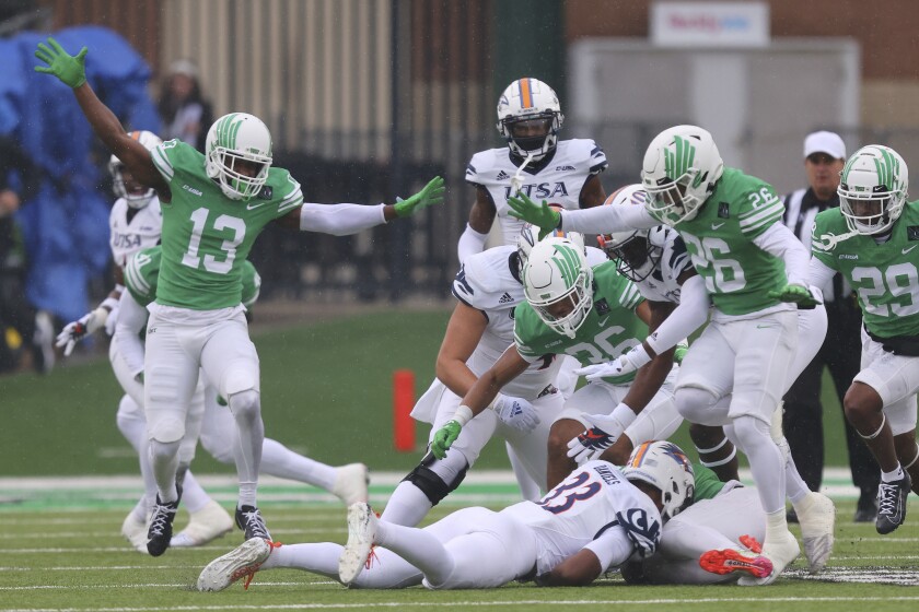 North Texas defensive back Jordan Rucker, left, celebrates with teammates after recovering a fumble during the first half of an NCAA college football game against UTSA in Denton, Texas, Saturday, Nov. 27, 2021. (AP Photo/Andy Jacobsohn)