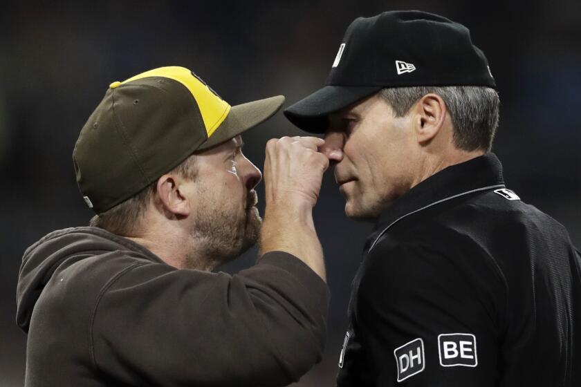 FILE - San Diego Padres manager Andy Green, left, argues with home plate umpire Angel Hernandez before being ejected between the third and fourth innings of the team's baseball game against the Pittsburgh Pirates, June 29, 2018, in San Diego. Longtime umpire Hernández, who unsuccessfully sued Major League Baseball for racial discrimination, is retiring immediately, announced Monday, May 27, 2024. (AP Photo/Gregory Bull, File)