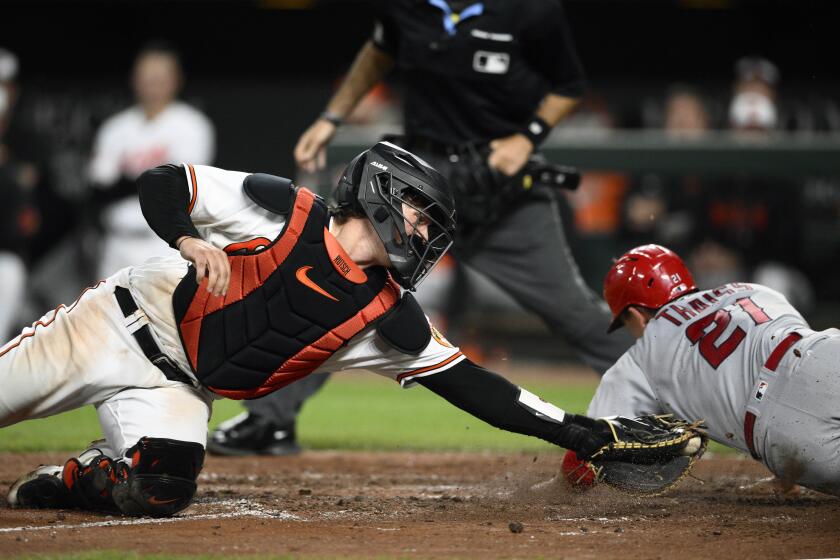 Los Angeles Angels' Matt Thaiss scores past Baltimore Orioles catcher Adley Rutschman, left, on a single by Gio Urshela during the sixth inning of a baseball game, Tuesday, May 16, 2023, in Baltimore. The Orioles won 7-3. (AP Photo/Nick Wass)
