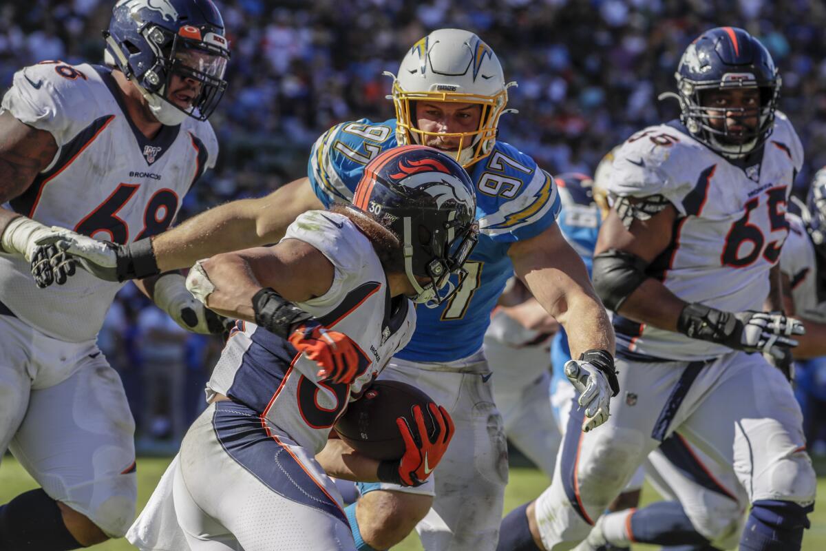 Chargers defensive end Joey Bosa (97) closes  on Denver Broncos running back Phillip Lindsay (30) during third-quarter action at Dignity Health Sports Park on Sunday.