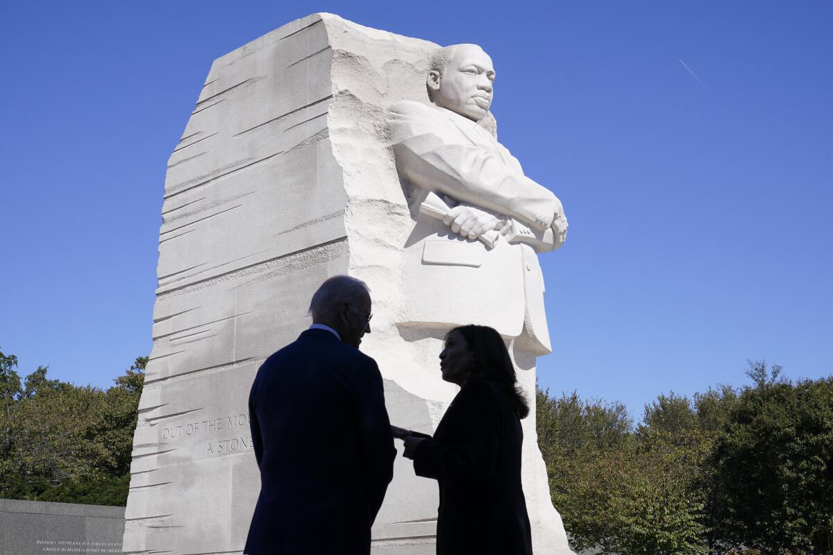President Biden and Vice President Kamala Harris chat with each other in front of the Martin Luther King, Jr. Memorial.