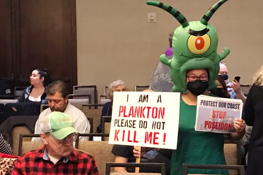 COSTA MESA CA MAY 12, 2022 - Dressed in a plankton costume, Zoey Lambe-Hommel joins people gathering prior to the start of the California Coastal Commission meeting Thursday, May 12, 2022 in Costa Mesa, where the Poseidon desalination plant in Huntington Beach will be discussed. (Allen J. Schaben / Los Angeles Times)