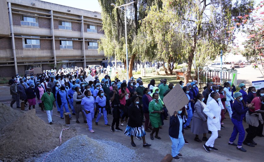 FILE -Health workers led by nurses take part in a demonstration over salaries at Parerenyatwa Hospital in Harare, on June, 21, 2022. As food costs and fuel bills soar, inflation is plundering people’s wallets, sparking a wave of protests and workers’ strikes around the world. (AP Photo/Tsvangirayi Mukwazhi)