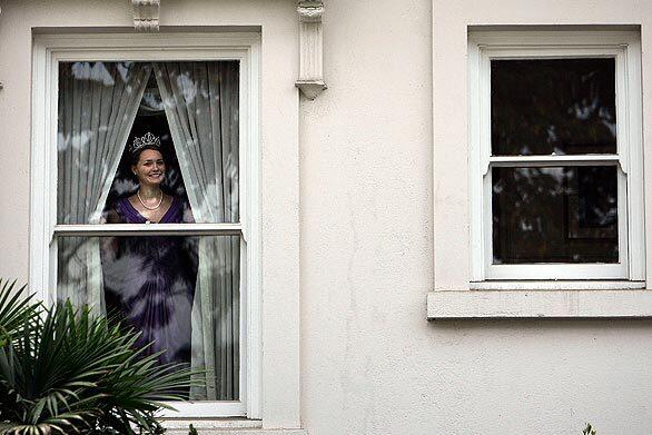 Quinn Young, 16, a princess in the Royal Court, peeks out from the dressing room window before the start of crowning ceremony.