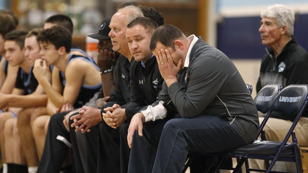 Corona del Mar coach Ryan Schachter holds his head as his team committed 24 turnovers and shot 52% from the free-throw line in an 82-78 loss at University on Tuesday.