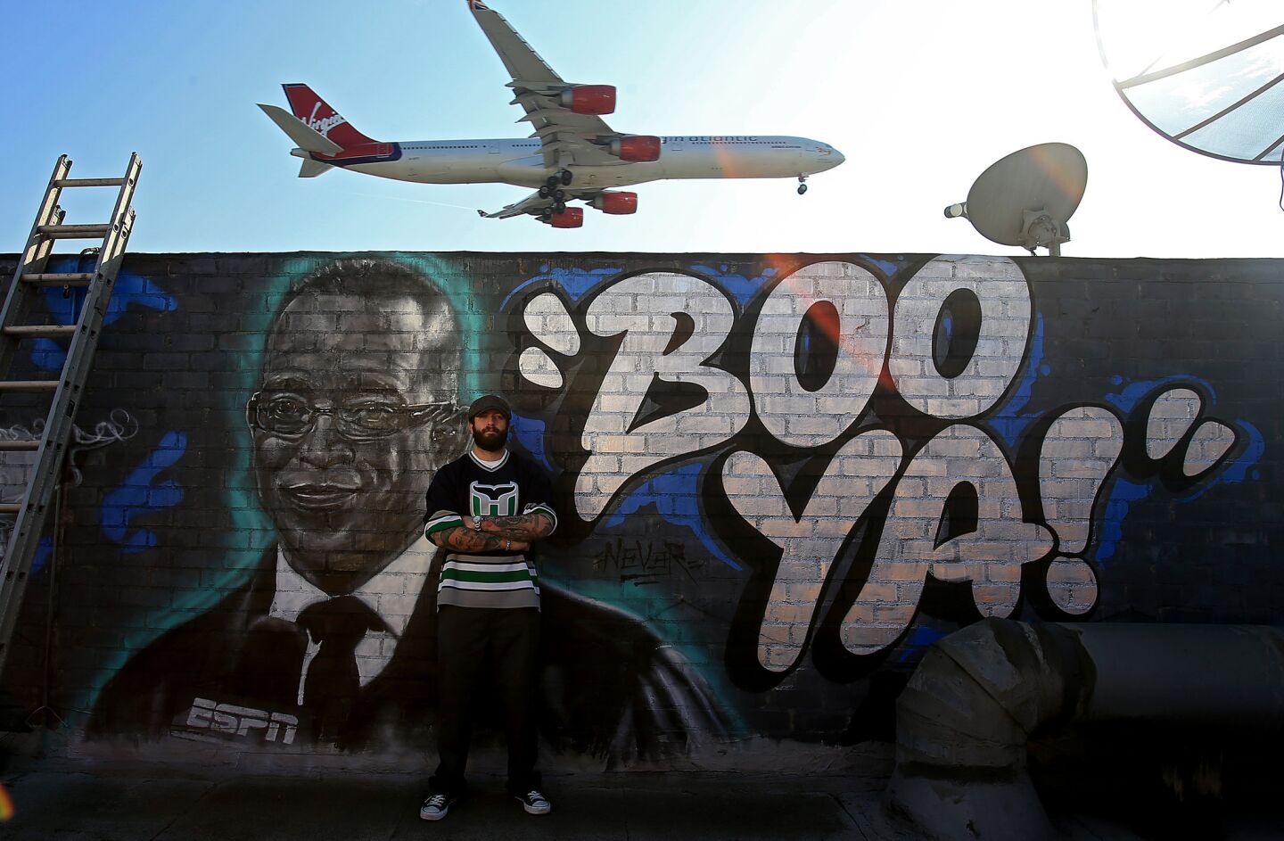 Artist Jonas Never painted a mural in honor of late ESPN sportscaster Stuart Scott on the rooftop wall of the Melody Bar & Grill near the flight path to LAX in Westchester.