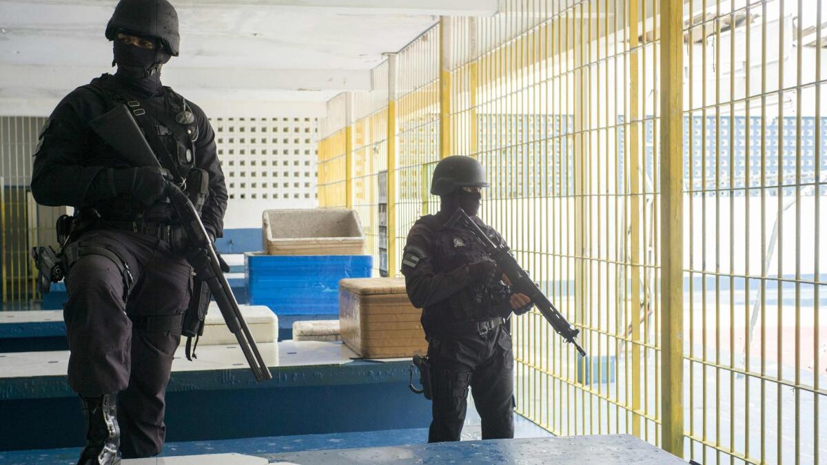 Security personnel stand guard in the inmate dining hall at the Anísio Jobim Penitentiary Complex, where 56 inmates were killed two weeks ago.