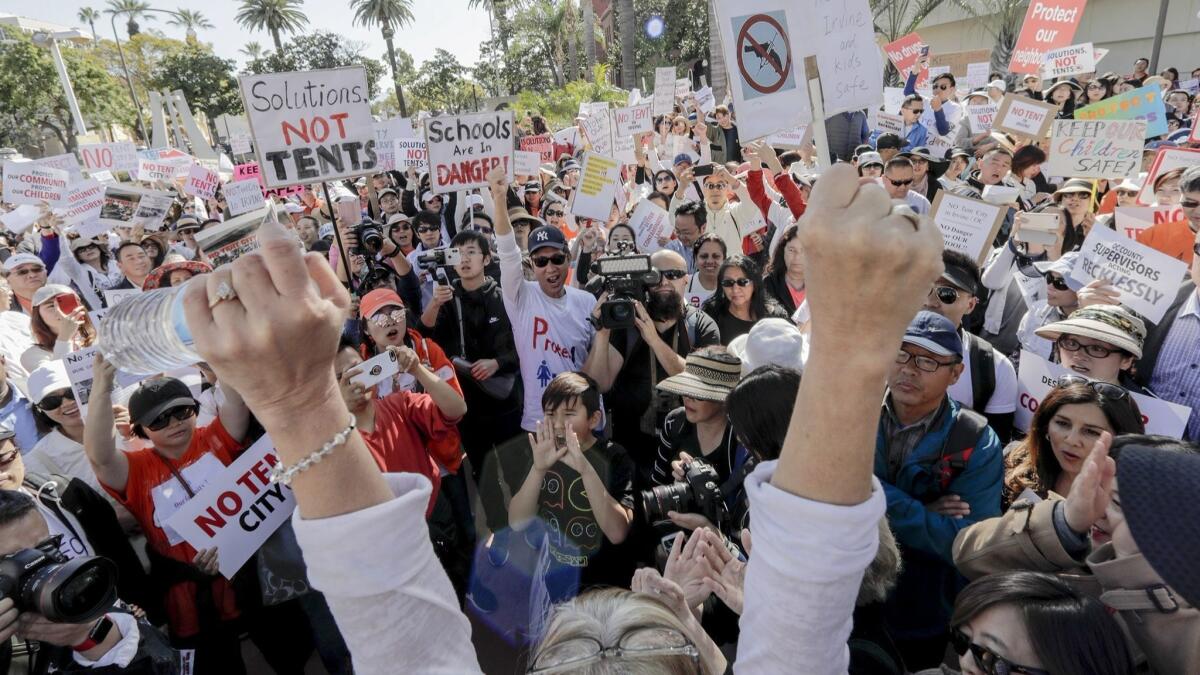 Residents of Irvine, Huntington Beach and Laguna Niguel protest Tuesday outside the Orange County Board of Supervisors meeting as the board discussed placing temporary homeless shelters in those communities.