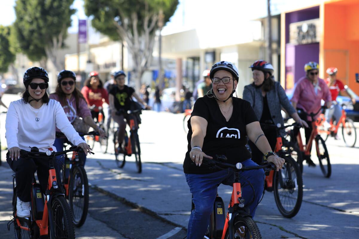 People ride bikes on a street.