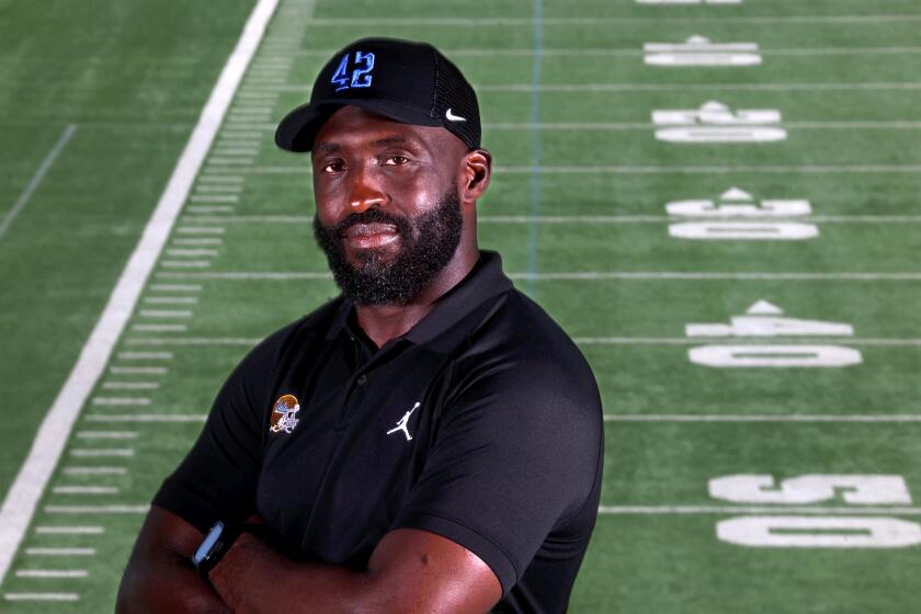 UCLA coach DeShaun Foster crosses his arms and smiles slightly while posing for a portrait 