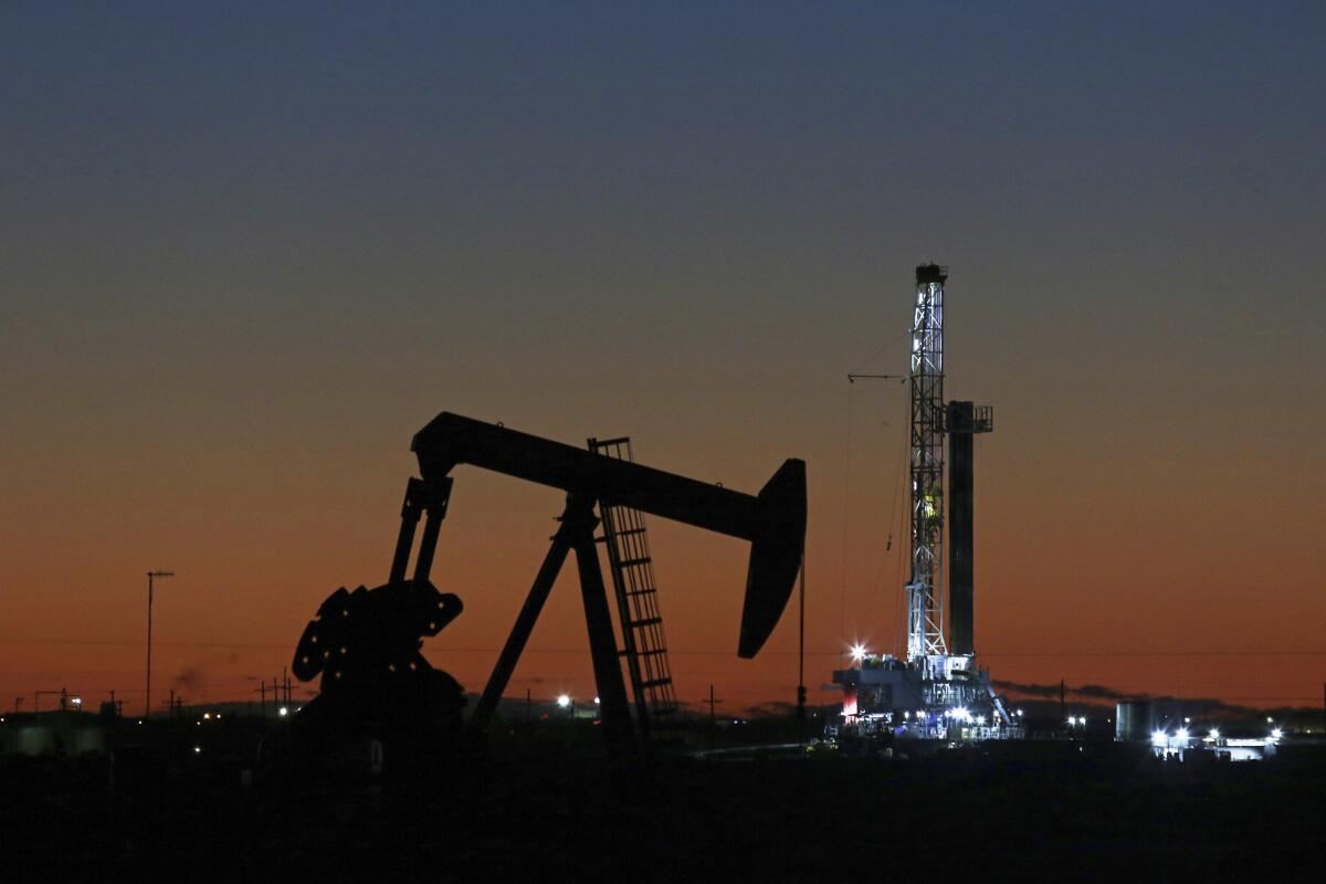 An oil rig and pump jack work in Midland, Texas, the nation's top oil-producing state.