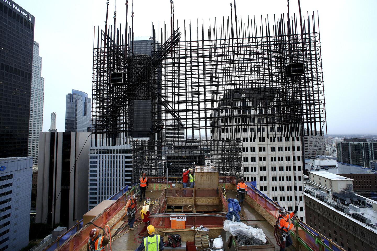 Dense as macrame, the rebar cages can weigh up to 32,000 pounds. Manufactured and assembled off-site, the cages are lifted by a tower crane onto the top of the concrete core where Otto Solis and his crew of rod busters position and fasten them.