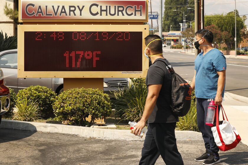 WOODLAND HILLS, CA - AUGUST 19: Anthony Aco and Troy Sacaguin, left to right, check out the thermometer at Calvary Church in Woodland Hills as it registers 117 degree's Fahrenheit Wednesday afternoon as the Southland's fiercest heat wave entered its second week threatening "excessive heat" and elevated fire danger. Los Angeles on Wednesday, Aug. 19, 2020 in Woodland Hills, CA. (Al Seib / Los Angeles Times