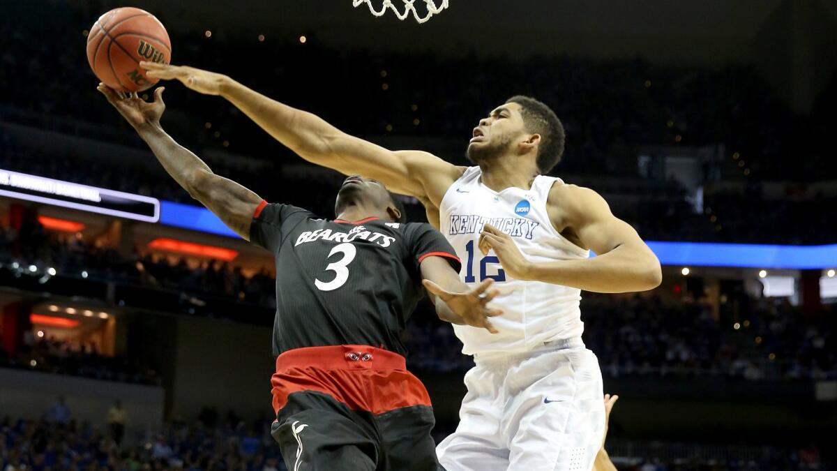 Kentucky's Karl-Anthony Towns, right, tries to block a shot by Cincinnati's Shaquille Thomas during a Wildcats' victory.