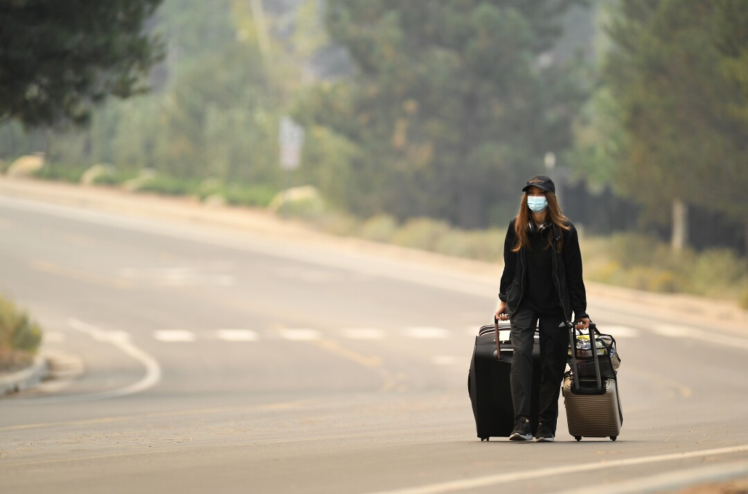 Raluca Savu rolls luggage down a road 