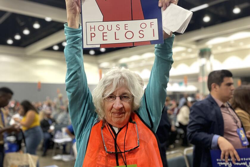 Los Angeles, California-May 27, 2023-A volunteer at the California Democratic Convention celebrates former Speaker Nancy Pelosi's speech on Saturday, May 27m 2023, at the Los Angeles Convention Center. (Melanie Mason / Los Angeles Times)