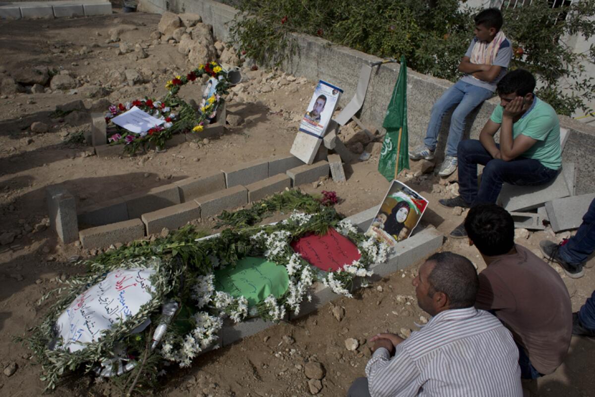 Palestinian mourners visit the grave of Riham Dawabsheh after her funeral in 2015. Her husband and child are buried next to her.