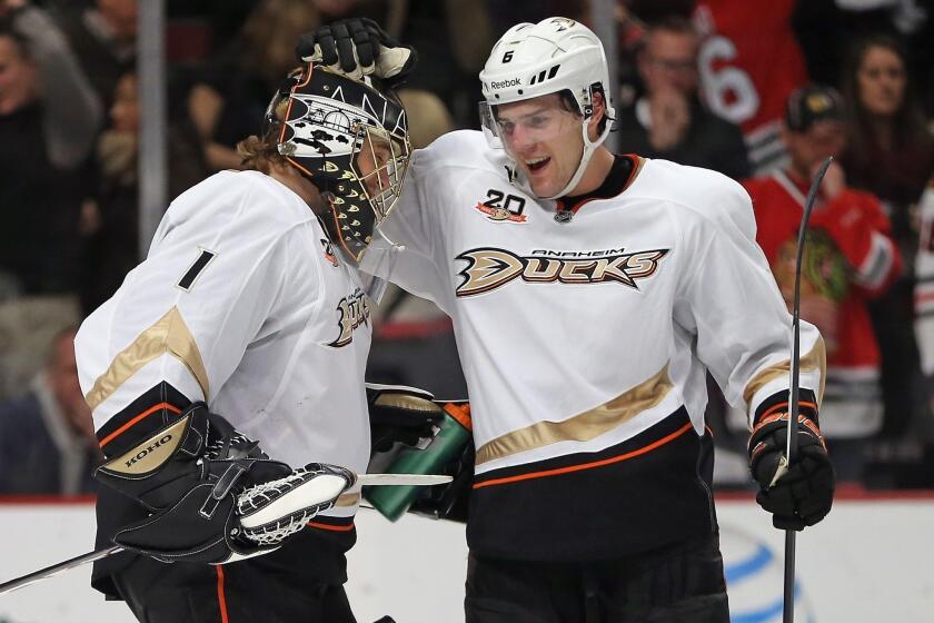 Ducks goalie Jonas Hiller is congratulated by teammate Ben Lovejoy following the Ducks' win over the Chicago Blackhawks on Friday.