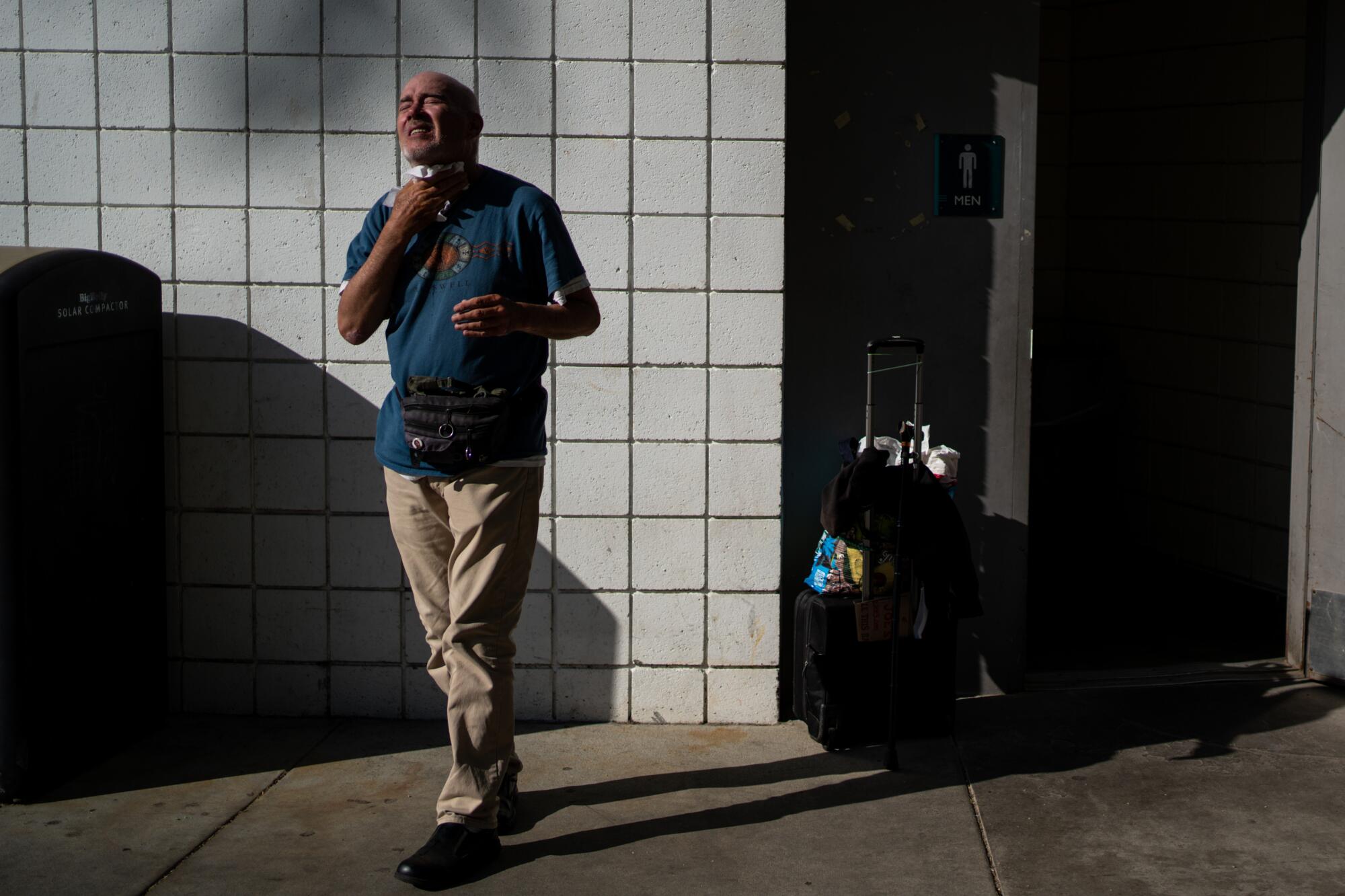 Terrance Whitten dries his face after leaving the restroom at Pan Pacific Park 