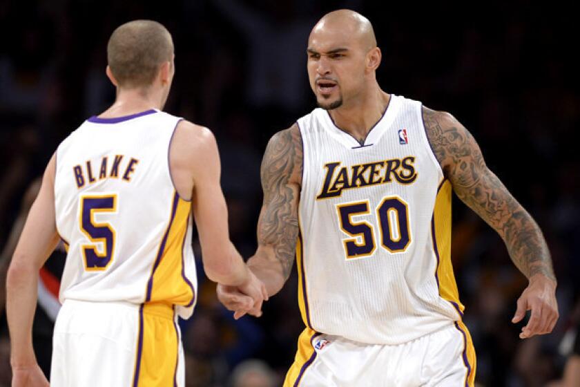 Lakers center Robert Sacre (50) celebrates with guard Steve Blake during a game against the Trail Blazers last week at Staples Center.