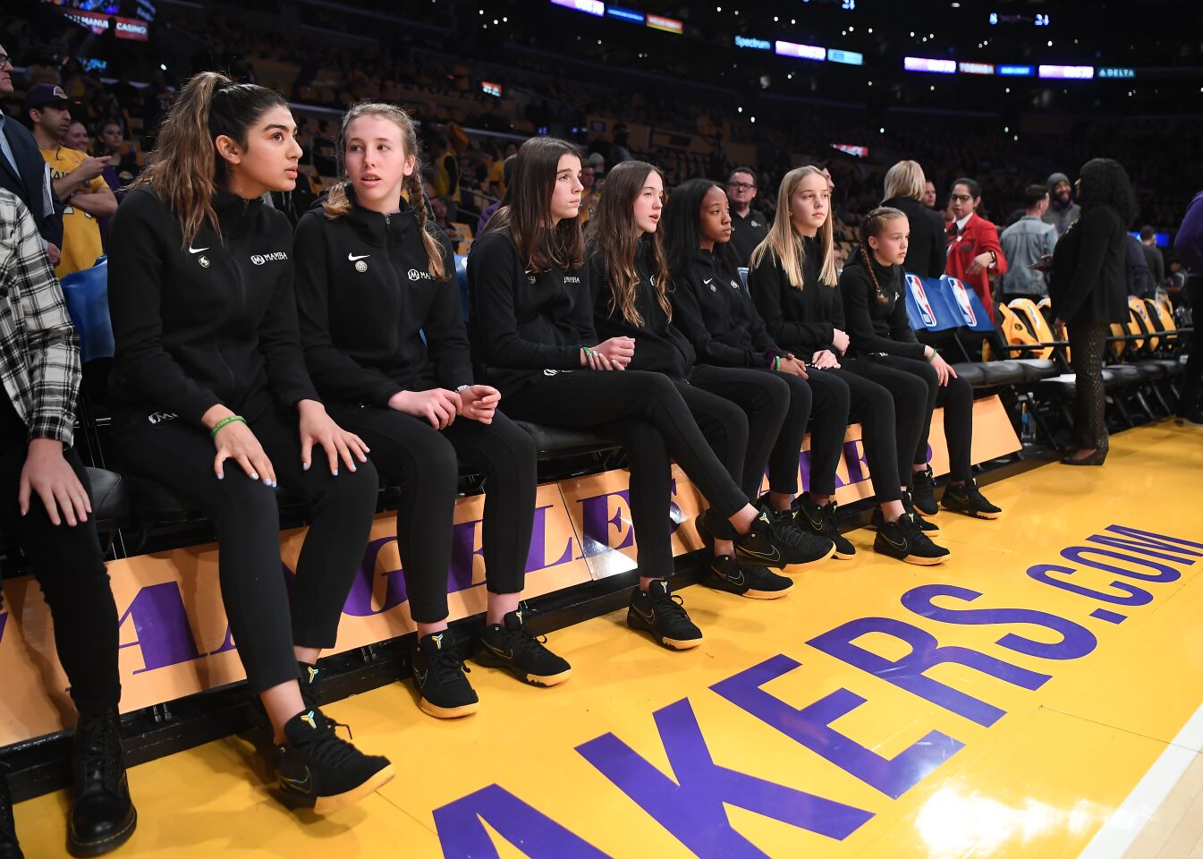 Members of the Black Mambas girls basketball team sit courtside before a pregame ceremony at Staples Center honoring their teammate Gianna Bryant and their coach Kobe Bryant on Jan. 31, 2020.