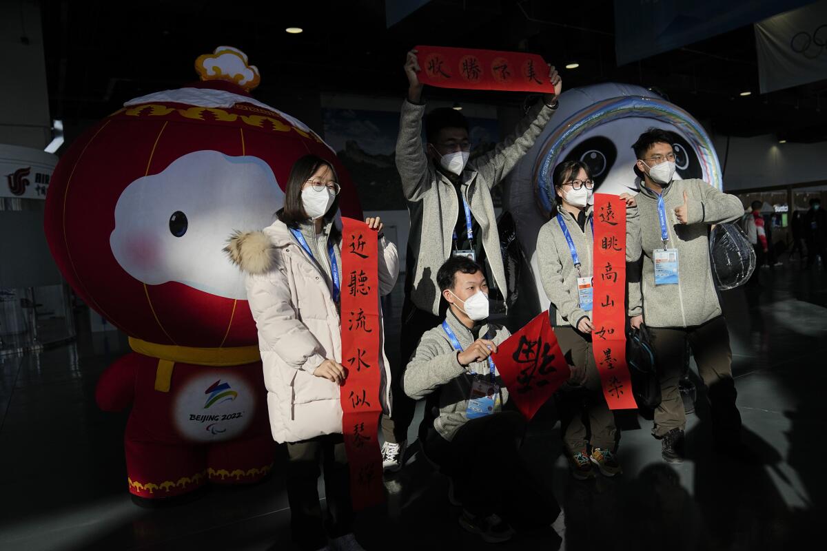 Olympic workers celebrate the Chinese New Year with Winter Olympics and Paralympics mascots.