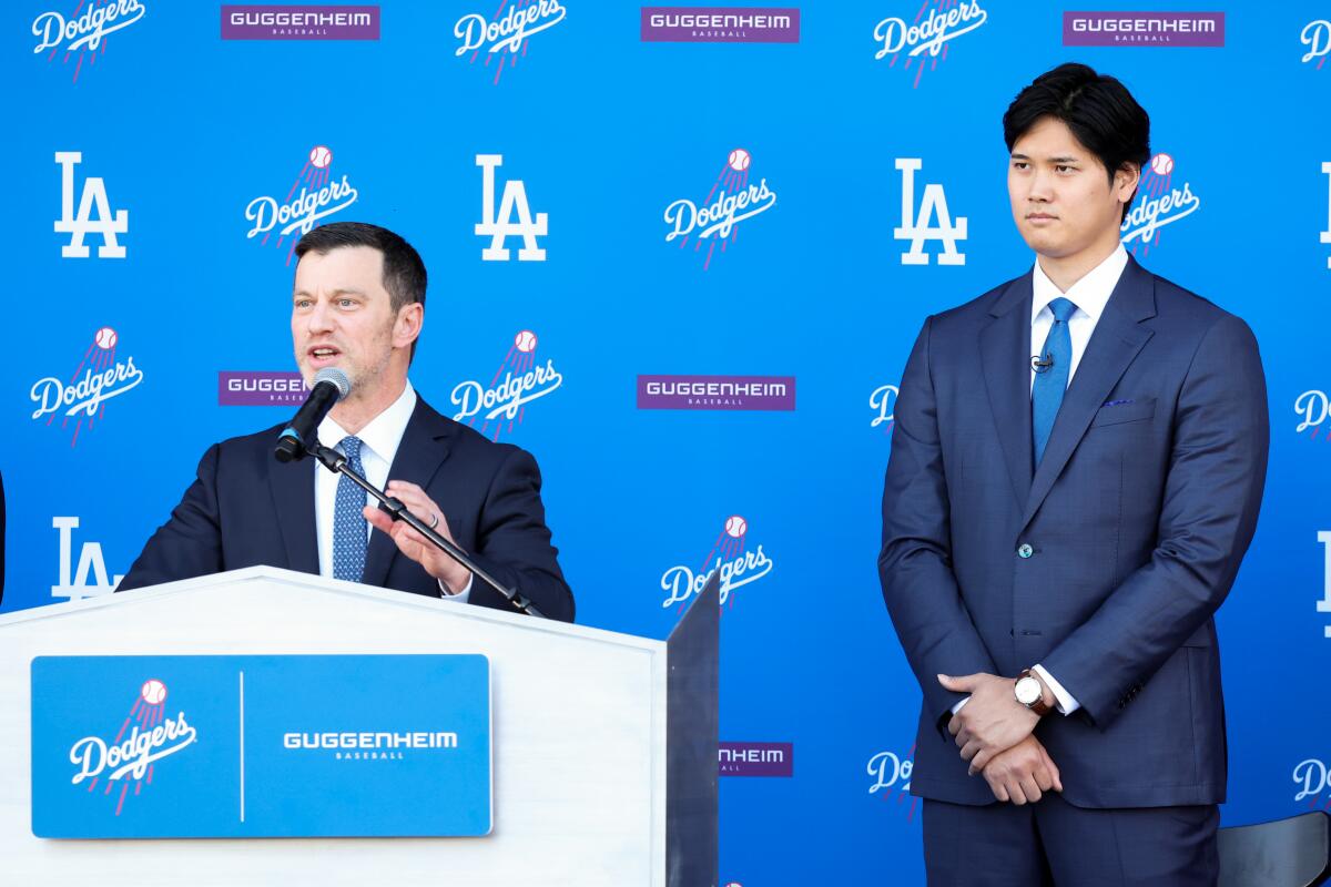 Dodgers president of baseball operations Andrew Friedman, left, speaks next to Shohei Ohtani on Dec. 14, 2023.