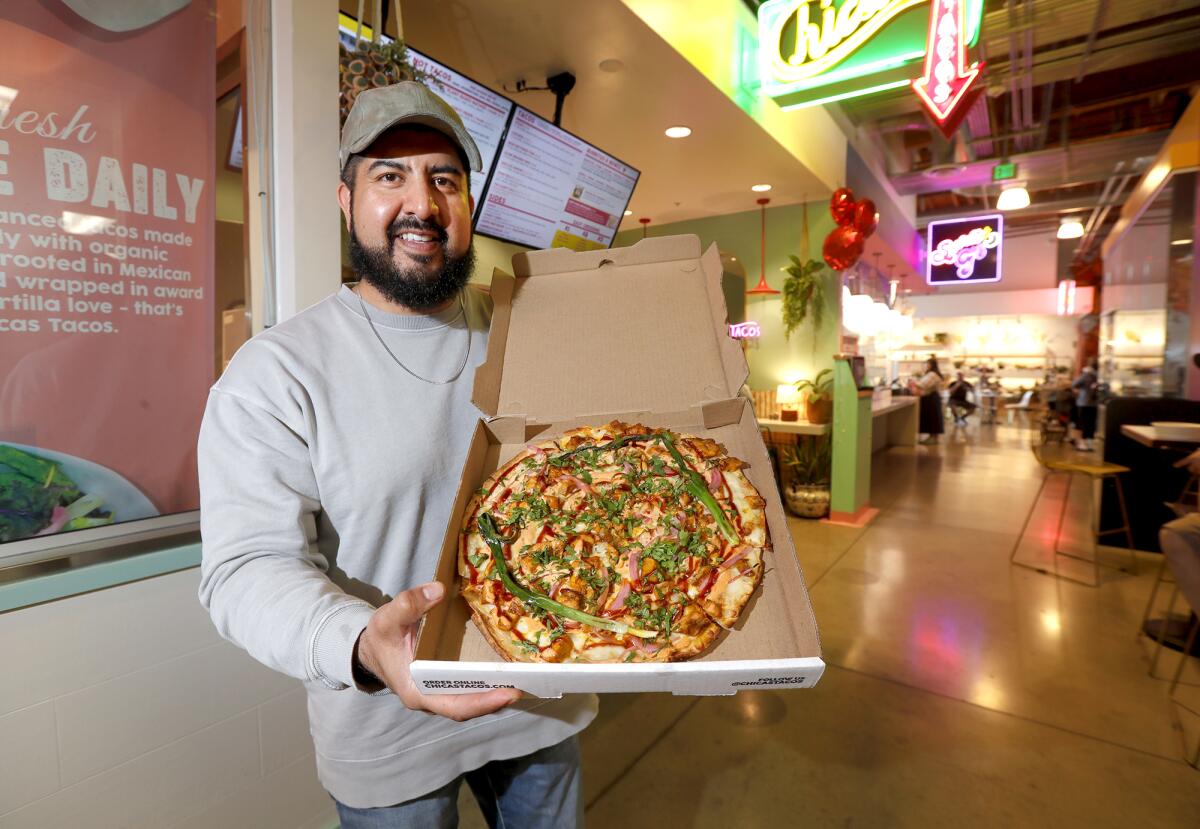 Eduardo Ruiz holds the chipotle BBQ chicken pizza Chicas Tacos at Rodeo 39 in Stanton.