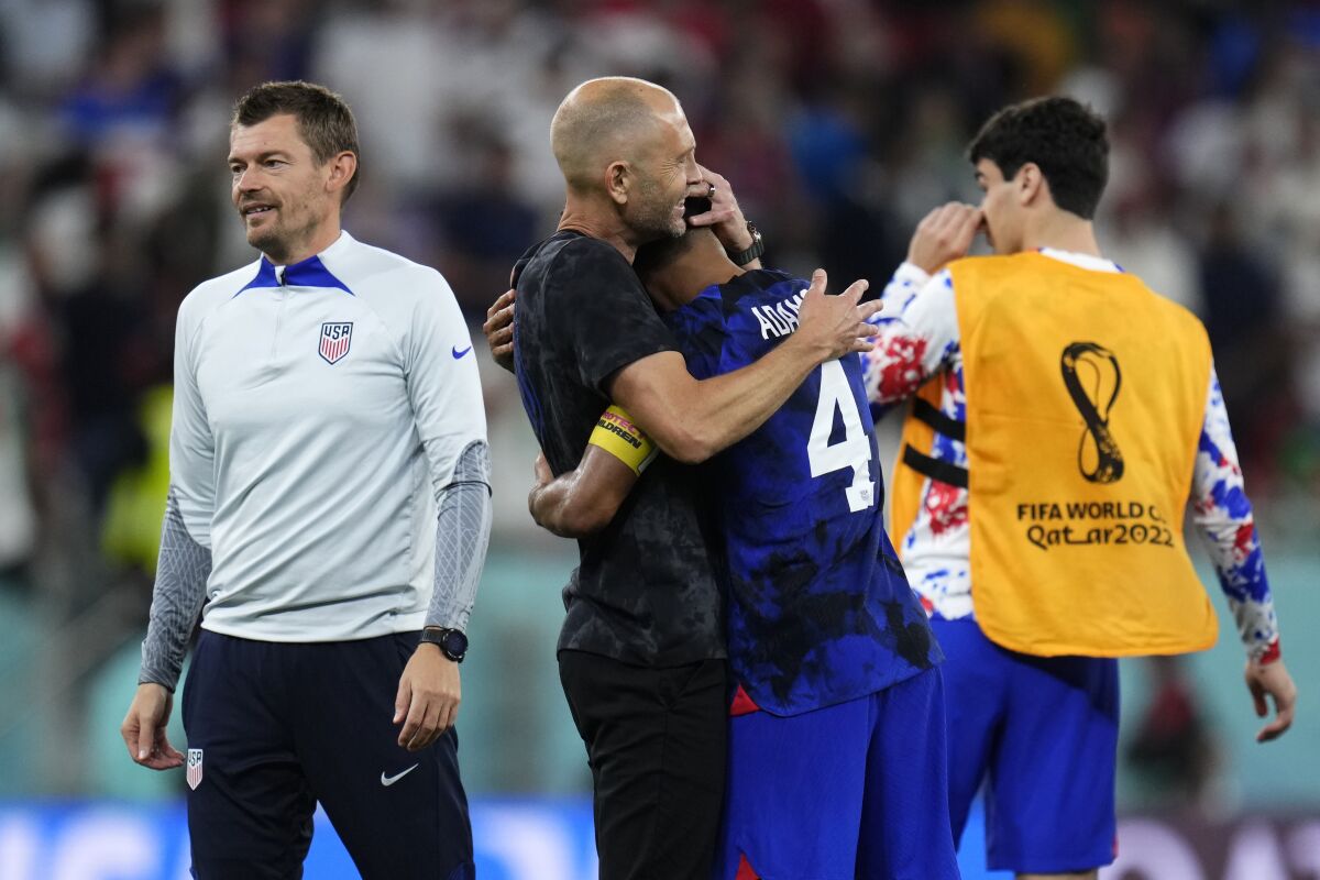 U.S. coach Gregg Berhalter hugs Tyler Adams after beating Iran at the World Cup