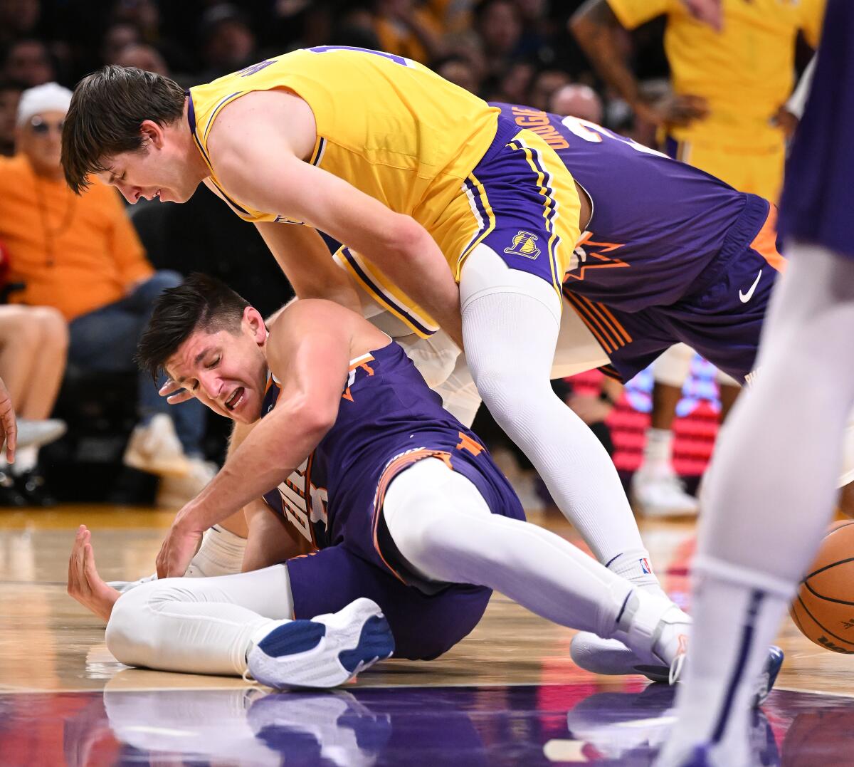Lakers guard Austin Reaves and Suns guard Grayson Allen battle for a loose ball.