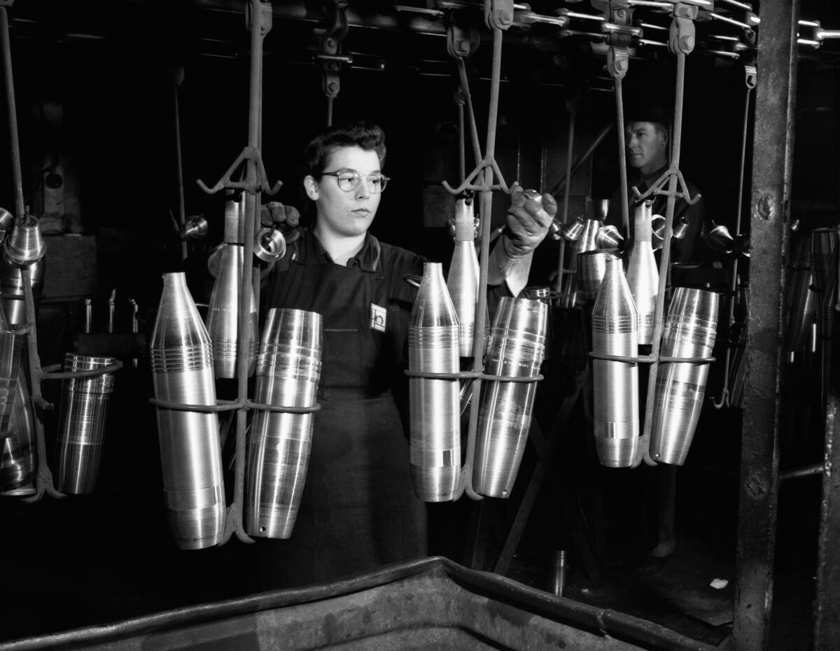 A woman works on a Detroit assembly line producing artillery shell casings in 1943